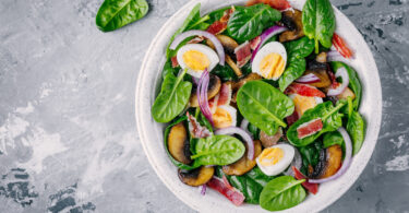 Photo de la recette : Recette de salade d'épinards avec oeufs, bacon, champignon et oignons rouges