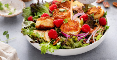 Photo de la recette : Recette de salade au chèvre frit, pomme et framboises à la vinaigrette avec oignons rouges