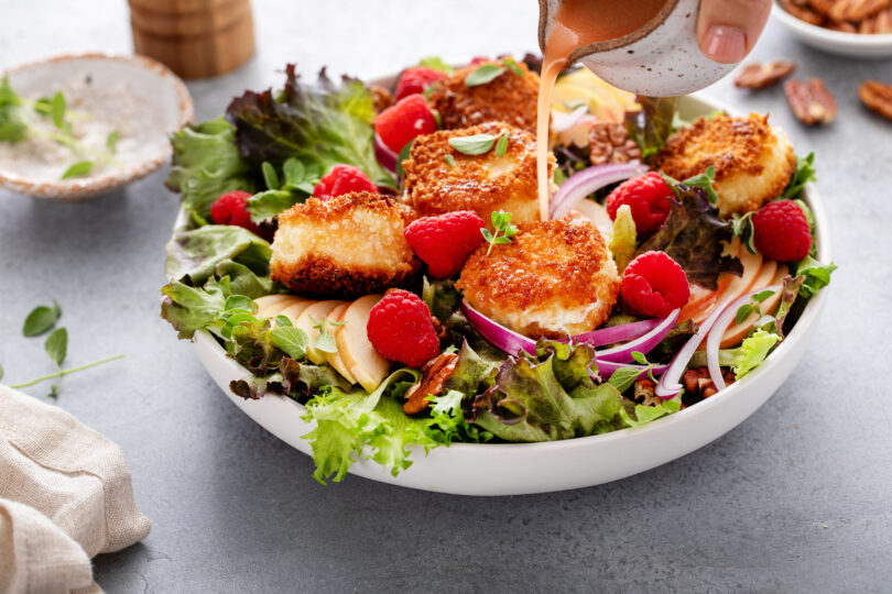 Photo de la recette : Recette de salade au chèvre frit, pomme et framboises à la vinaigrette avec oignons rouges